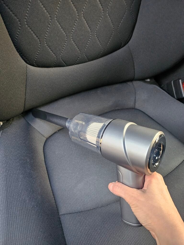 Portable car vacuum cleaning a car seat and tight spaces