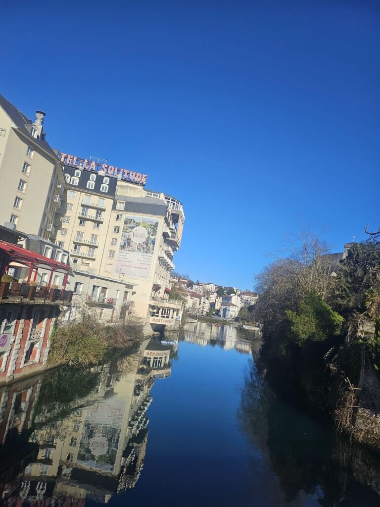 Hotels reflected in the river in Lourdes, France