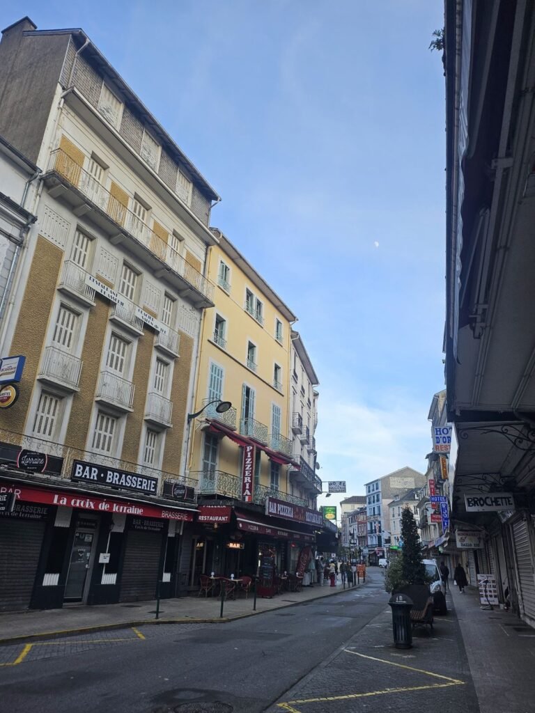 Quiet street in Lourdes with mountains in the distance