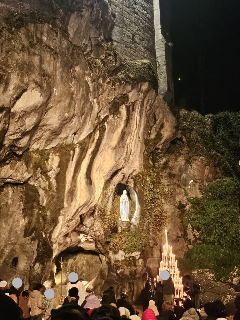 Pilgrims praying the candlelight Rosary at the Grotto of Massabielle