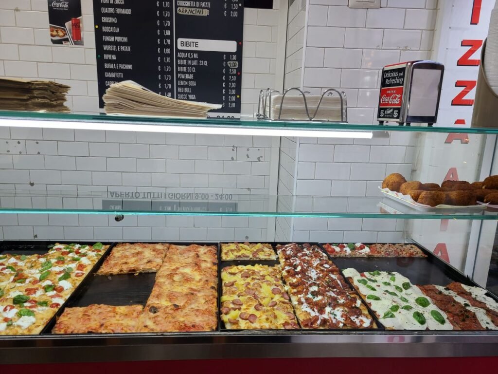 Pizza by the slice on display at a small shop in Rome